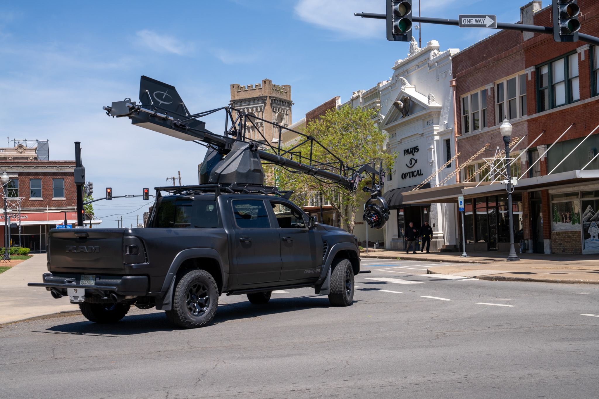 photo of truck with camera crane used for filming vehicles on street near downtown Paris