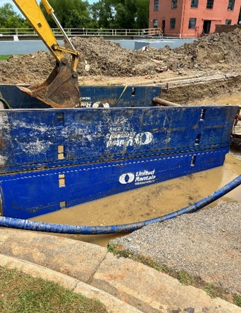 excavation area around leaking water pipe with cave in prevention device in place Opens in new window